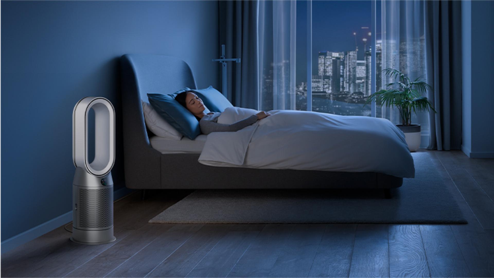 Dyson purifier in a dark bedroom with someone sleeping peacefully 