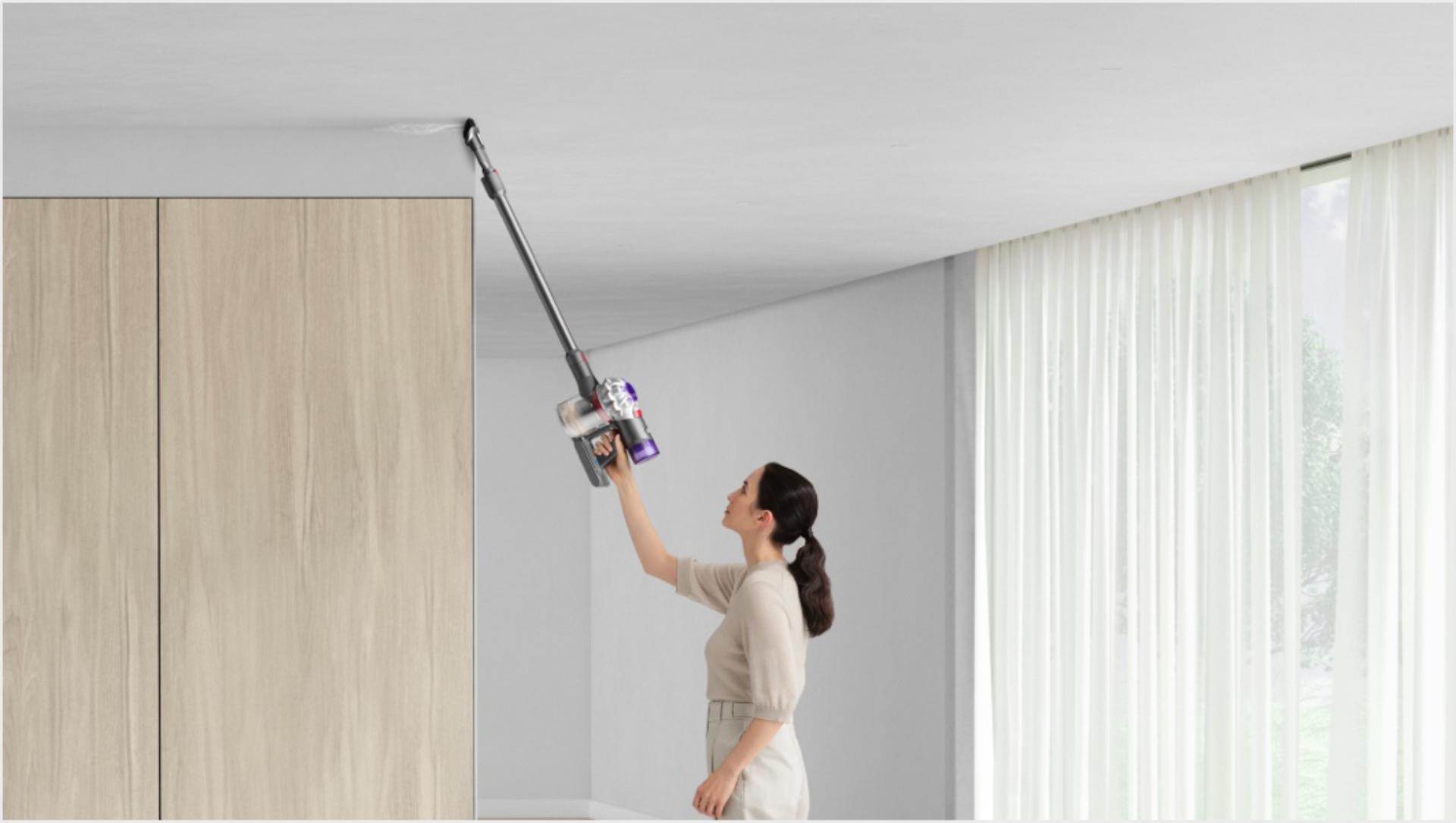 Woman cleaning up high with Dyson V8 vacuum