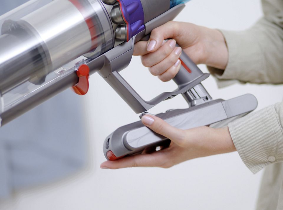 Woman mounting the Dyson Gen5detect™ onto the wall dock.