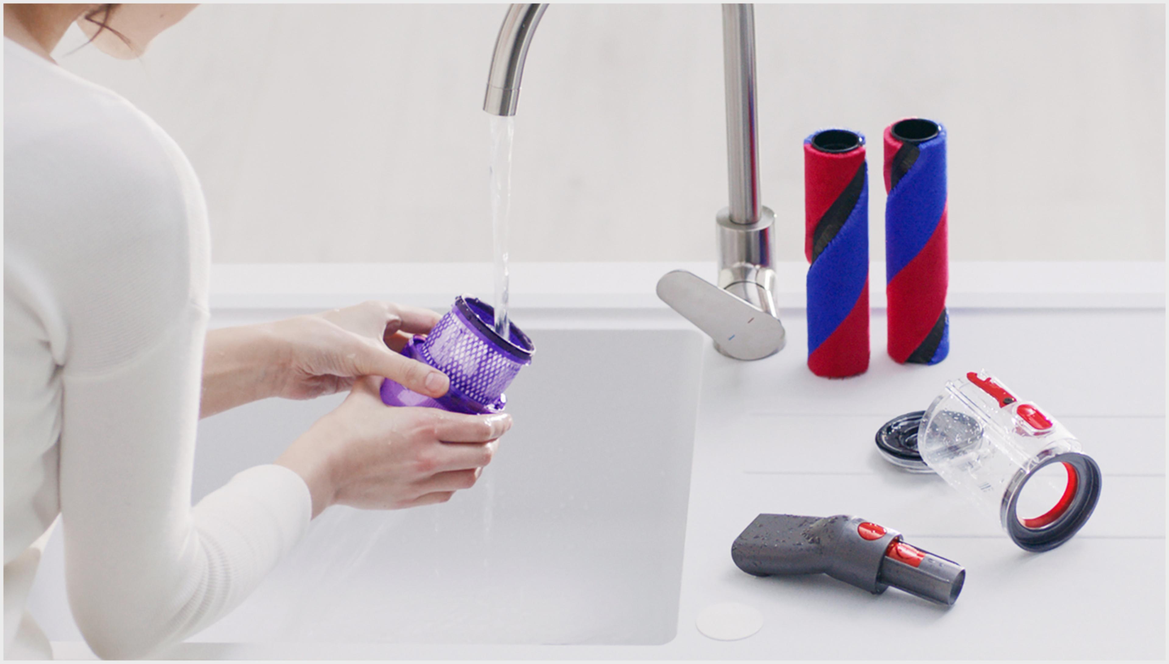 Woman washing vacuum parts in the sink