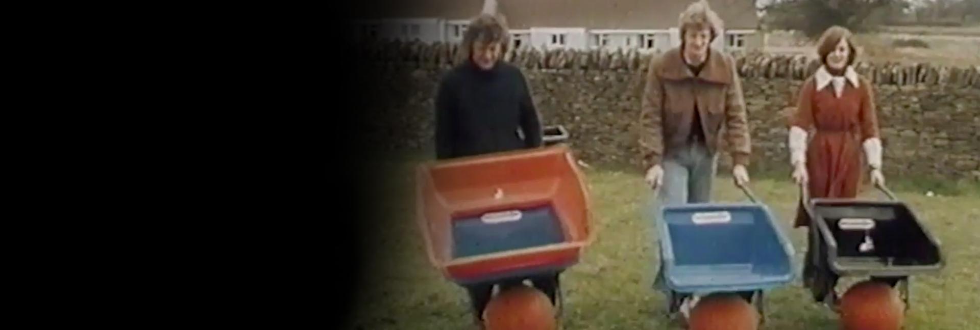 James and Deirdre Dyson pushing Ballbarrows around a garden