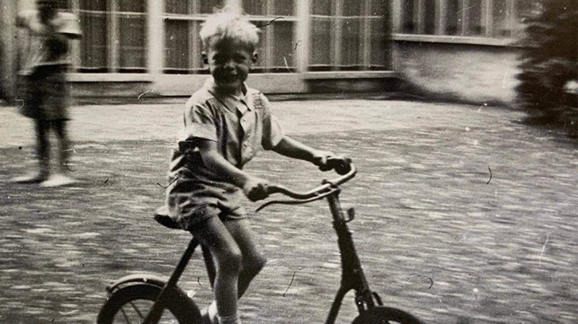 Young James Dyson cycling a small Triang bike