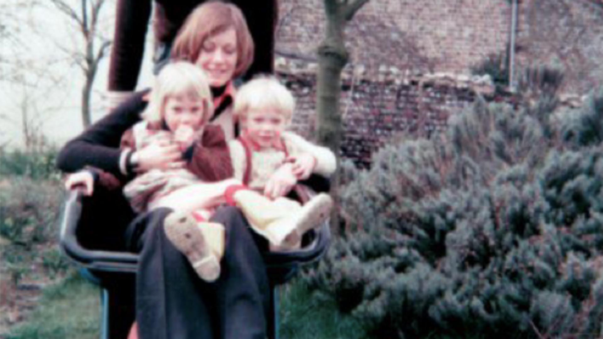 Deirdre Dyson sitting in a Ballbarrow with Emily and Jake sitting on her lap