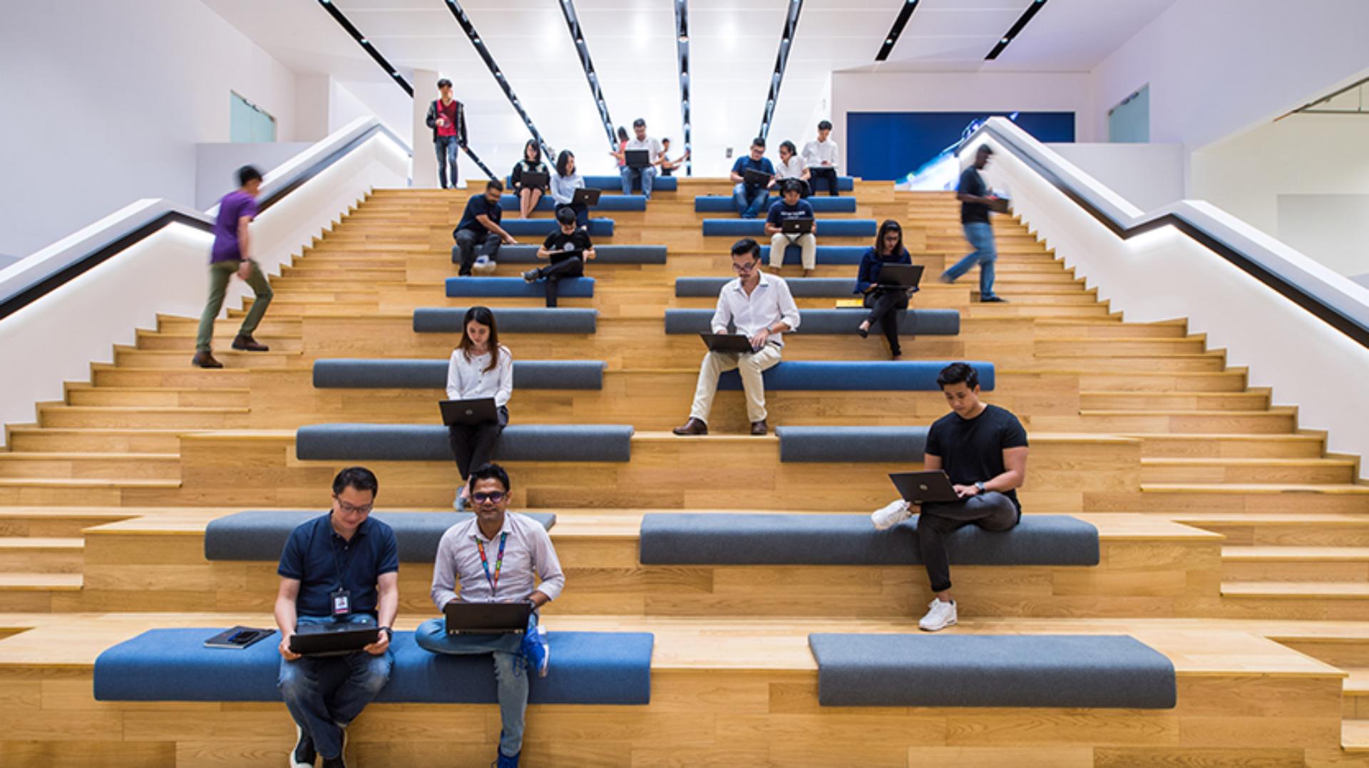 Employees and Colleagues sitting on the working stairs area at the Development Centre