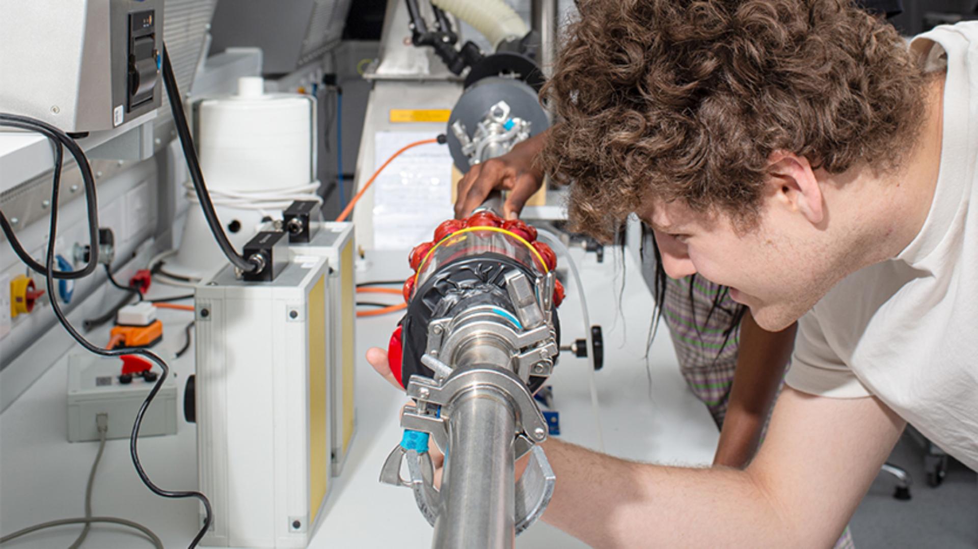 A student gaining hands-on experience with an engineering test model