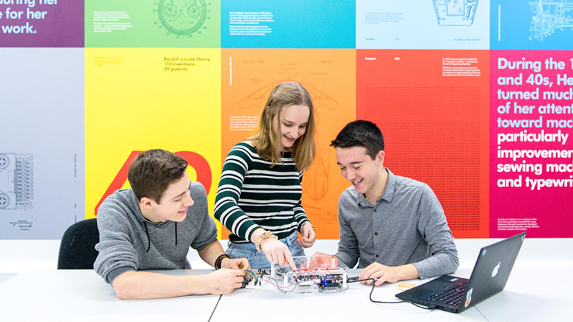 Three students learning whilst working on a project together