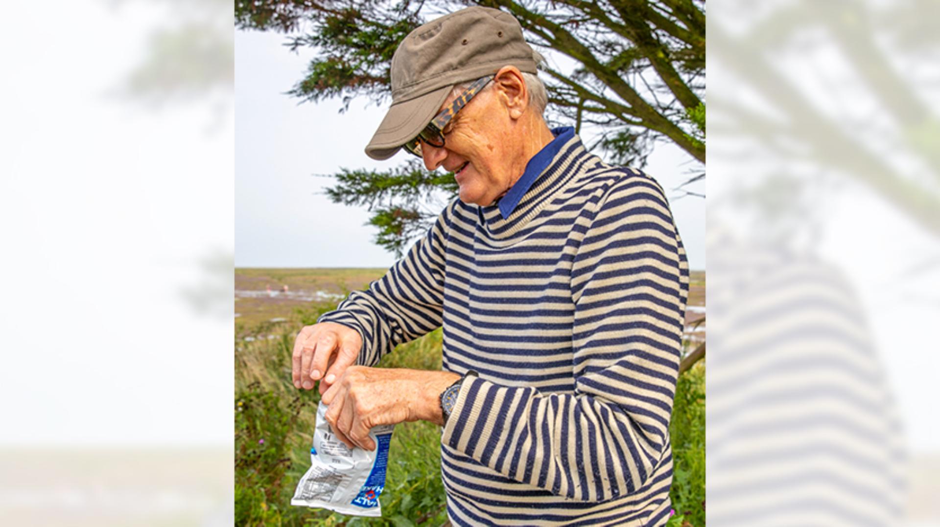 James Dyson holding a bag of Smiths potato crisps