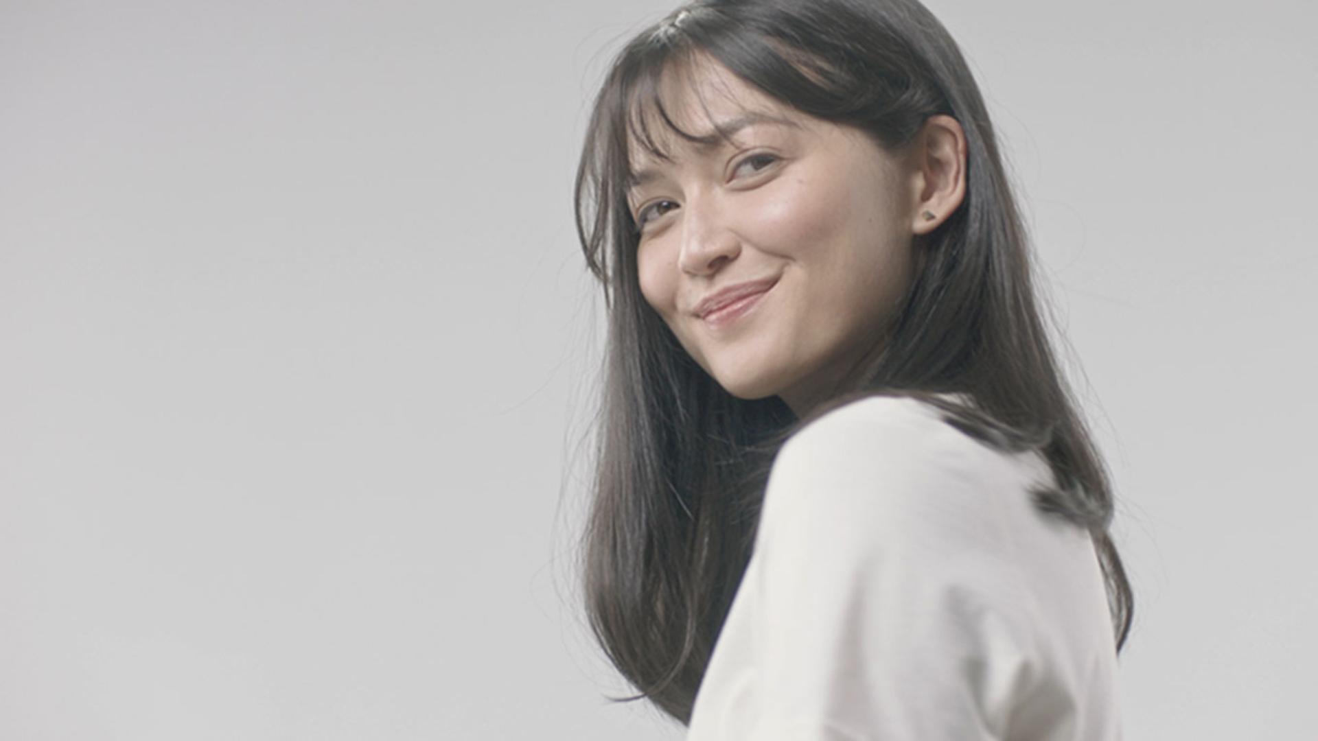 Dark, fine-haired lady with soft curls at the ends