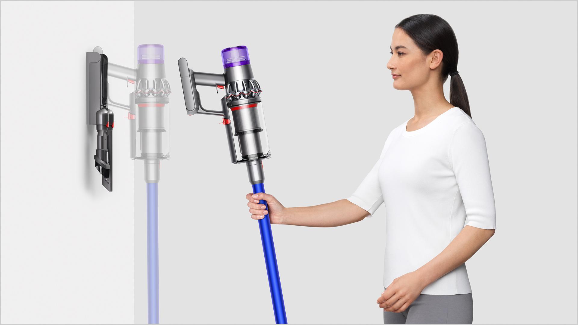 Woman placing Dyson V11™ vacuum into wall charging dock