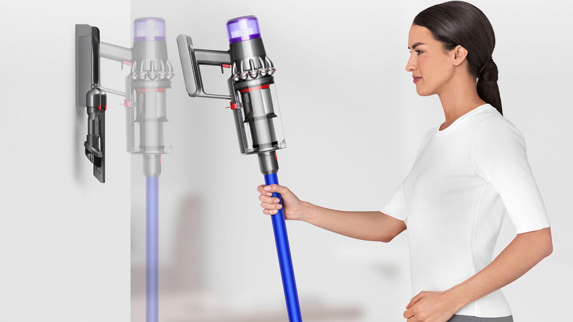 Woman placing Dyson V11 vacuum into wall charging dock