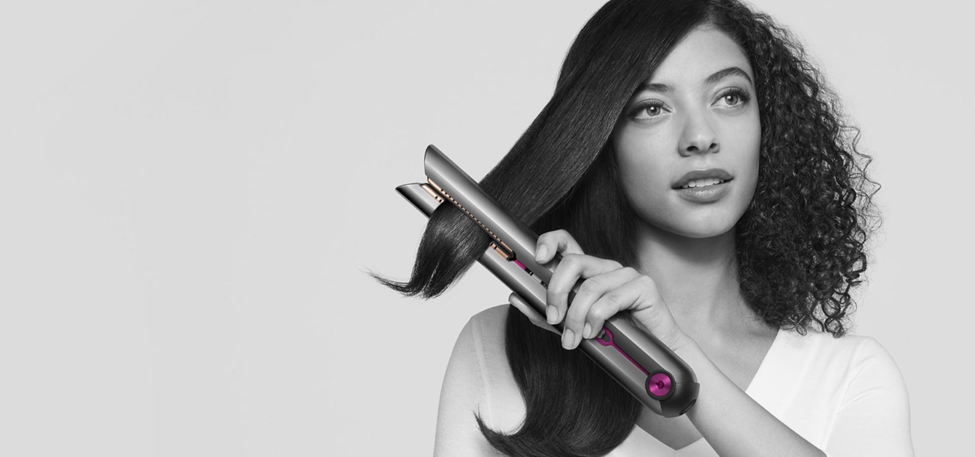 Woman straightening her hair with the Dyson Corrale™ straightener