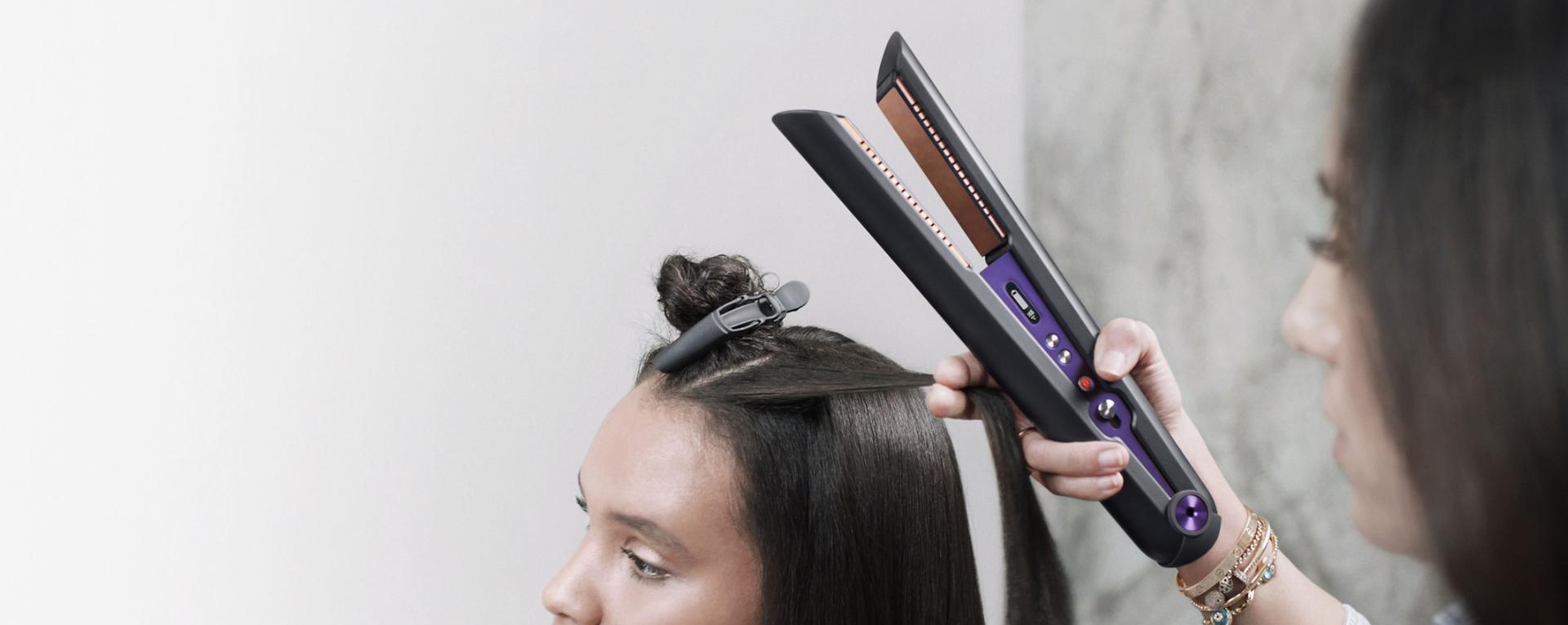 Close up of professional stylist using the Dyson Corrale hair straightener