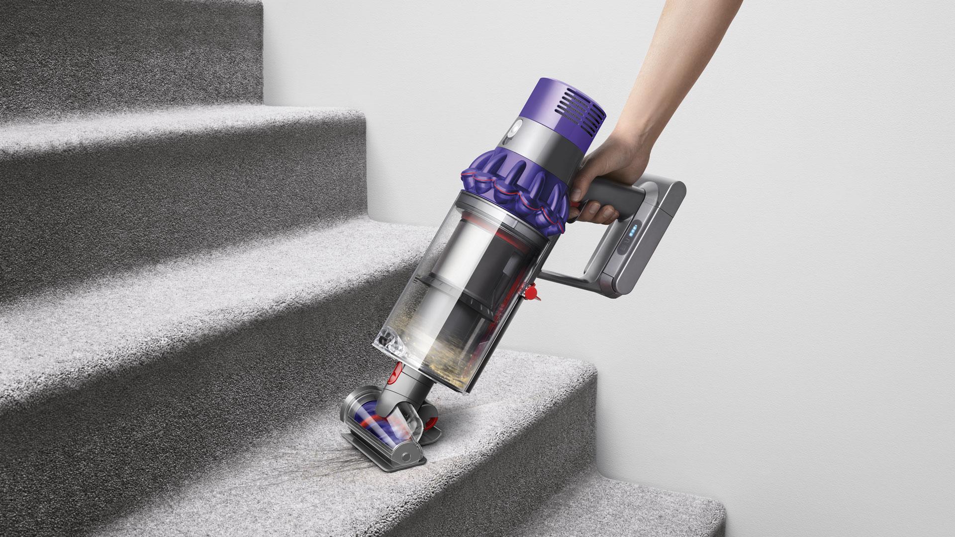 Dyson Cyclone V10 vacuum cleaner being used a handheld to clean car interior