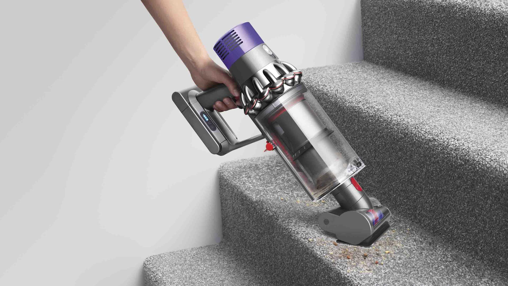 Dyson Cyclone V10 vacuum cleaner being used a handheld to clean car interior