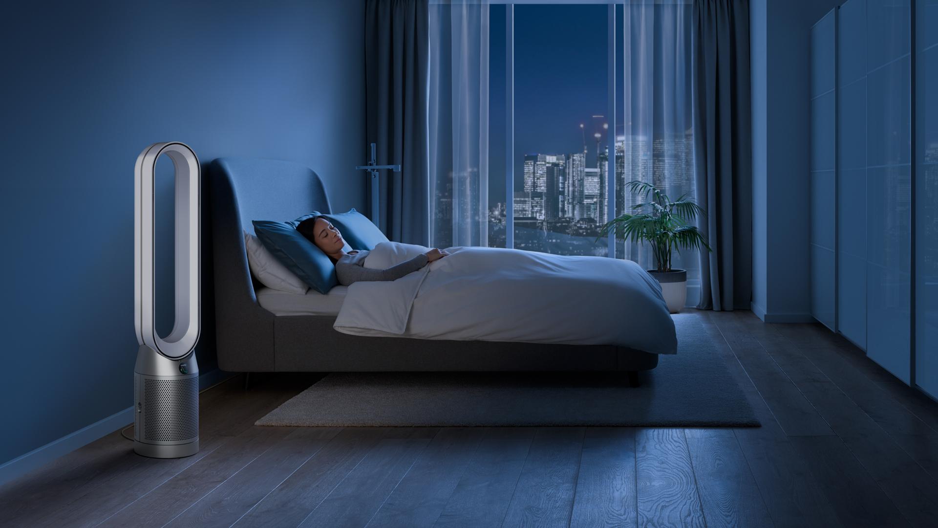 Dyson purifier in a dark bedroom with someone sleeping peacefully 