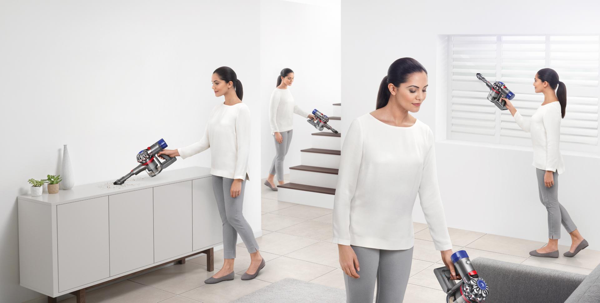 Lady cleaning the entire room with a Dyson handheld 