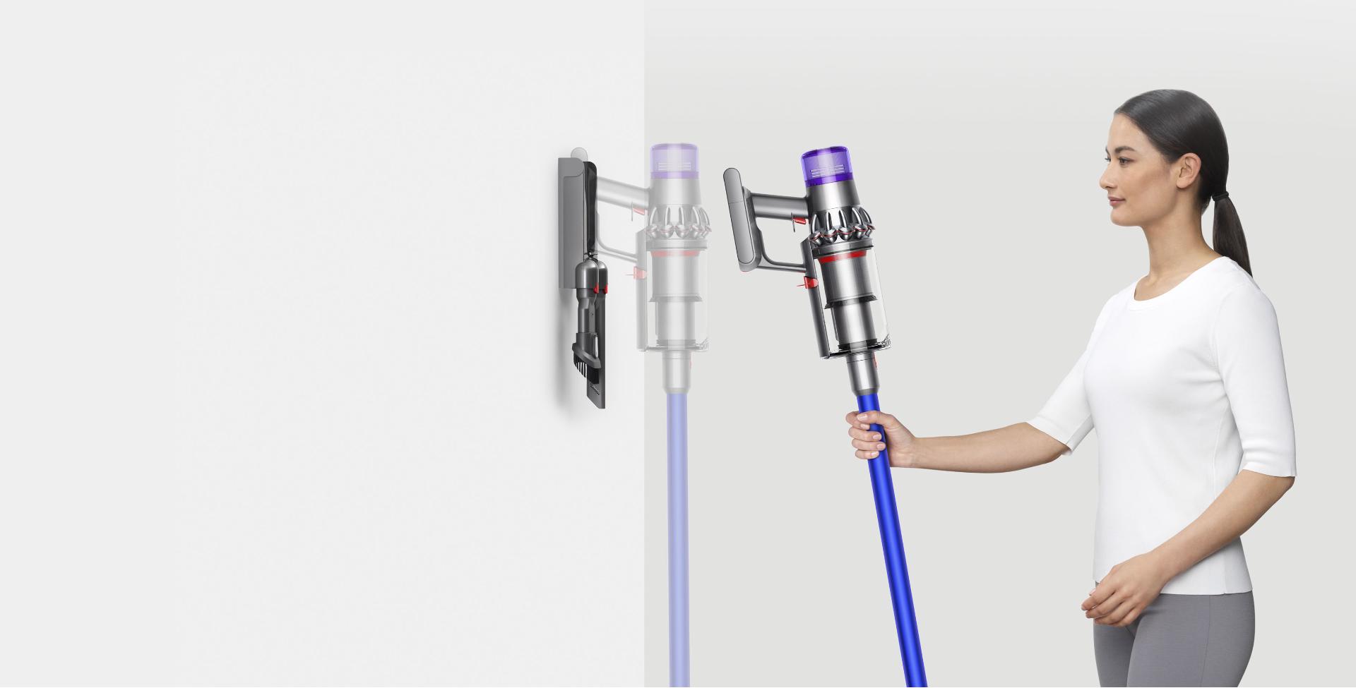 Woman placing Dyson V11™ vacuum into wall charging dock